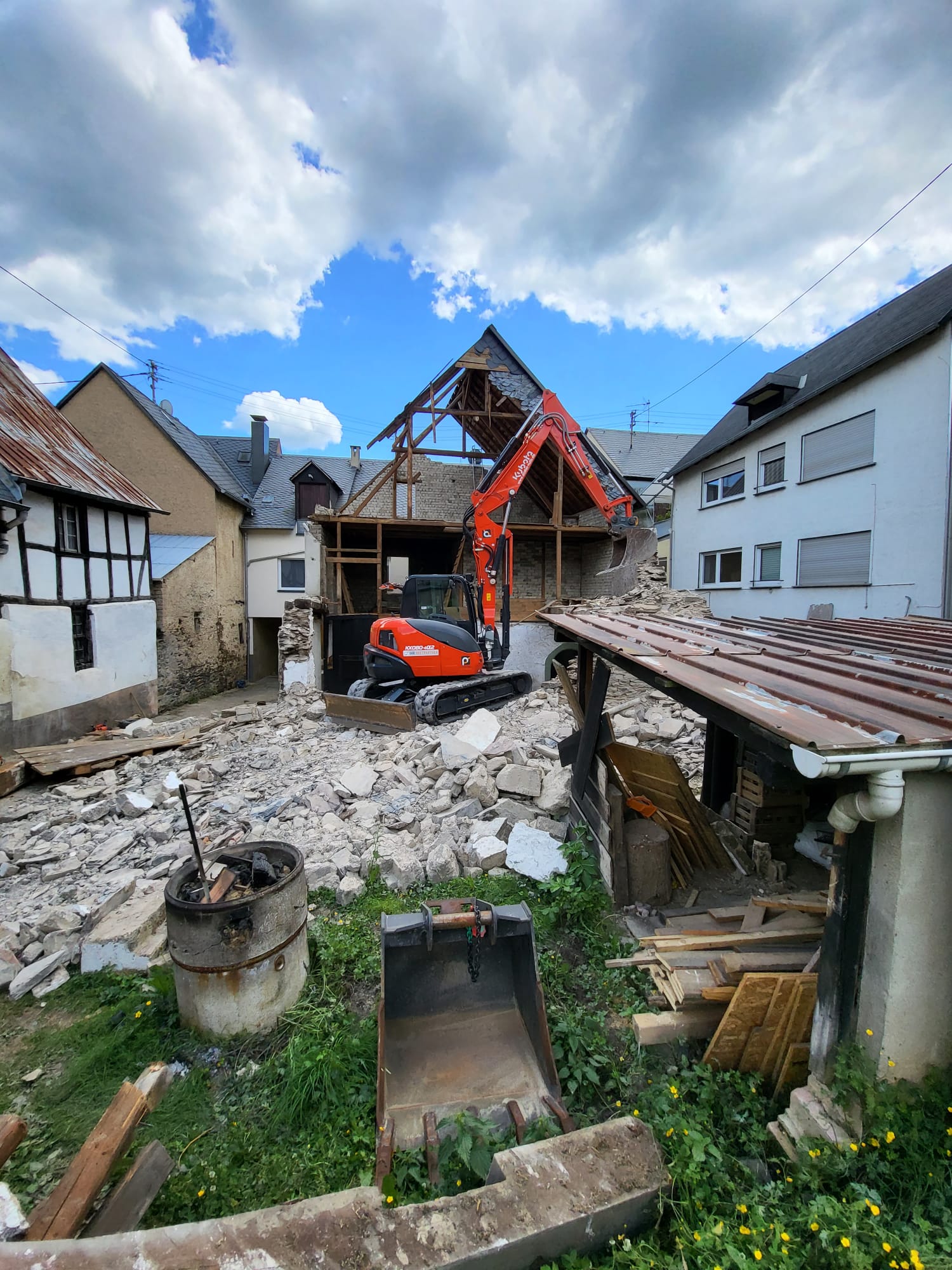 Minibagger beim kontrollierten Rückbau eines Nebengebäudes in einem Moselort